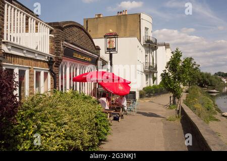 Les gens qui mangent en plein air à l'extérieur de la maison publique de Bell et Crown sur Strand-on-the-Green, Chiswick, Hounslow, Londres, Angleterre, ROYAUME-UNI Banque D'Images