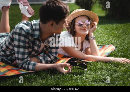 Teens Garçon Fille Ang portant sur la couverture dans le parc. Banque D'Images