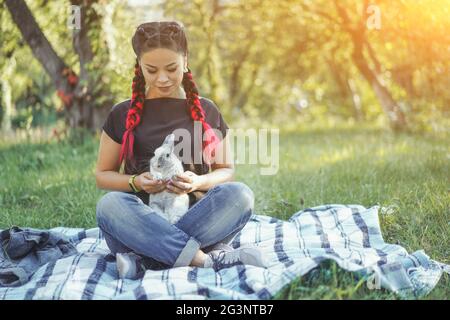 Pretty Asian Girl Hugging Bunny sur la nature d'été Banque D'Images