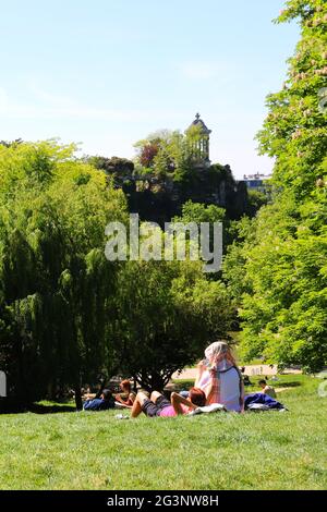 PARIS (75). 19E, PARC DES BUTTES-CHAUMONT, VUE SUR LE TEMPLE DE SIBYLLE, PELOUSE ET PERSONNAGES Banque D'Images