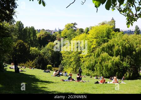 PARIS (75). 19E, PARC DES BUTTES-CHAUMONT, VUE SUR LE TEMPLE DE SIBYLLE, PELOUSE ET PERSONNAGES Banque D'Images