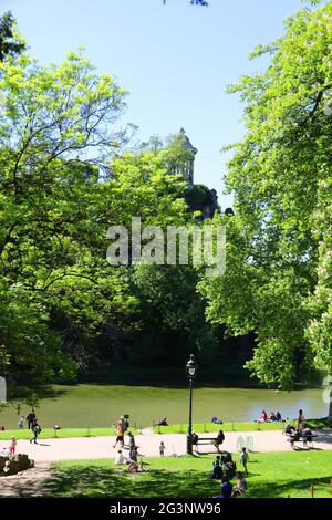 PARIS (75). 19E, PARC DES BUTTES-CHAUMONT, VUE SUR LE TEMPLE DE SIBYLLE, PELOUSE ET PERSONNAGES Banque D'Images