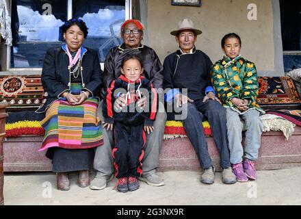 (210617) -- LHASSA, le 17 juin 2021 (Xinhua) -- Sonam (2e L, arrière) pose pour une photo de groupe avec des membres de la famille au village de Xaga, canton d'EMA, comté de Namling, ville de Xigaze, région autonome du Tibet du sud-ouest de la Chine, le 18 avril 2021. Sonam, 86 ans, résidant du village de Xaga, a commencé à travailler dur lorsqu'il avait 13 ans dans un manoir local, où, outre la garde des enfants du propriétaire du manoir, il a dû grader les animaux pendant la journée et les garder nourris pendant la nuit. Il lui-même, cependant, n'avait pas suffisamment de nourriture et de vêtements, et a été forcé de dormir avec les animaux au niveau de la bergerie. « J'avais été verbal Banque D'Images