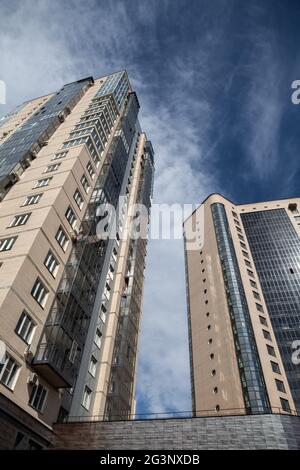 Bâtiments urbains à plusieurs étages en brique et en verre contre un ciel bleu Banque D'Images