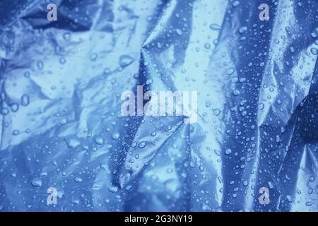 Humidifier la surface de couverture en plastique froissé avec des gouttes de pluie Banque D'Images