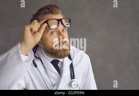 Studio gros plan portrait du médecin montrer l'émotion du visage de surprise prendre des lunettes Banque D'Images
