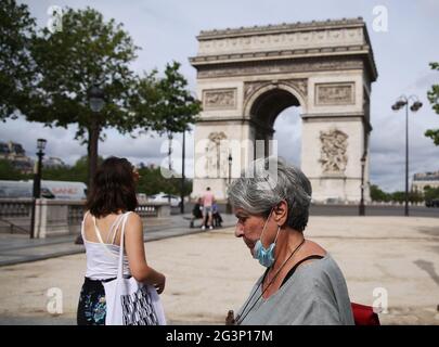 (210617) -- PARIS, 17 juin 2021 (Xinhua) -- les gens marchent près de l'Arc de Triomphe à Paris, France, 17 juin 2021. Le Premier ministre français Jean Castex a annoncé mercredi que les gens pourraient cesser de porter des masques à l'extérieur à partir de jeudi et que le couvre-feu de nuit sera également levé à partir de dimanche, les indicateurs COVID-19 du pays continuant à baisser. (Xinhua/Gao Jing) Banque D'Images