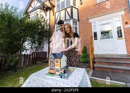 UTILISATION ÉDITORIALE SEULEMENT les acheteurs de première fois, George Isaacs et Lauren Turner se voient présenter un gâteau de célébration ÔFirst-HomeÕ à l'extérieur de leur nouvelle maison à Redditch, Créé par Ben Cullen, le Bake King, pour aider les nouveaux propriétaires à marquer leur étape dans l'achat de leur maison, alors que des recherches de Halifax ont révélé qu'un cinquième des Britanniques dépenseraient moins pour un mariage depuis la pandémie et que d'autres priveraient l'achat d'une première maison. Même si les couples considèrent l'achat d'une maison comme un engagement plus important qu'un mariage, seuls les deux cinquièmes des jeunes envisageraient de célébrer la réussite avec leurs proches. Banque D'Images