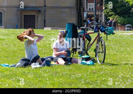 Femmes cyclistes reposant sur l'herbe, Cathedral Green, River Derwent, Riverside, Derby, Derbyshire, Angleterre, Royaume-Uni Banque D'Images