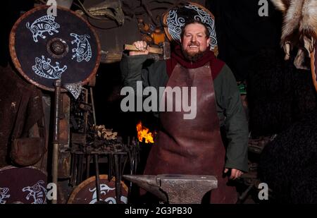 Viking forge des armes et des épées dans le smithy. Un homme dans les vêtements d'un guerrier est dans le smithy Banque D'Images