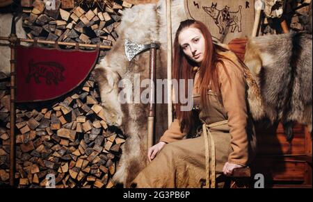 La femme des Vikings se posant sur le fond de l'ancien intérieur des Vikings. Banque D'Images