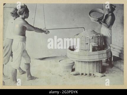Des hommes ont estampillé du riz avec des matériaux anciens dans les Antilles néerlandaises. Partie d'un album de famille avec des photos d'une famille hollandaise-indienne et d'une fabrique de sucre à PurnWorejo. Banque D'Images