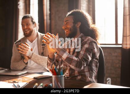 Applaudissements de jeunes travailleurs indépendants dans Loft style Office Banque D'Images