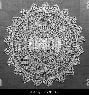 Dentelle faite à la main sur fond noir. Dentelle en tissu Macrame doily. Serviette décorative en dentelle blanche crochetée Banque D'Images