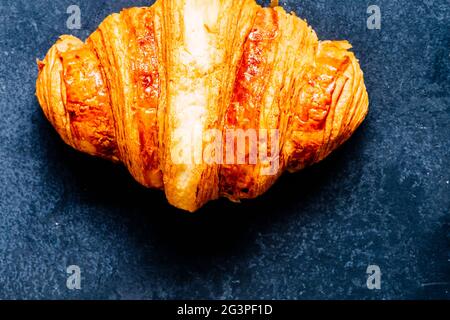 Croissant français doré sur fond sombre, vue sur le dessus de la cuisine Banque D'Images