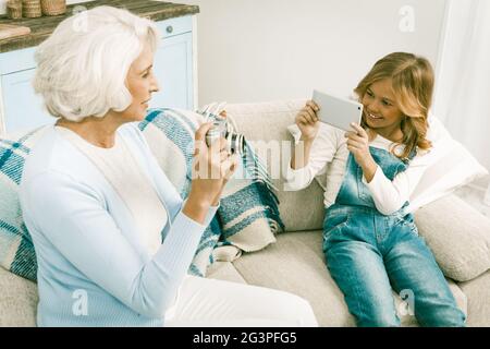 Grand-Mère Et Petite-Fille Qui Font Des Photos En Utilisant Différentes Technologies Banque D'Images