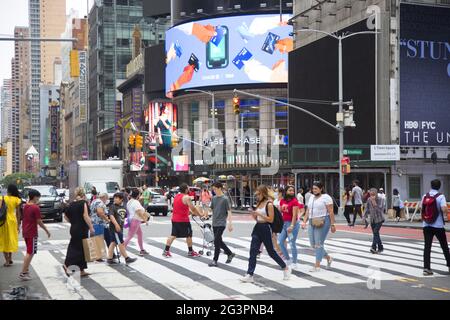 Les gens traversent la 42nd Street sur Broadway à l'extrémité sud du quartier de Times Square à Manhattan, New York City. Banque D'Images