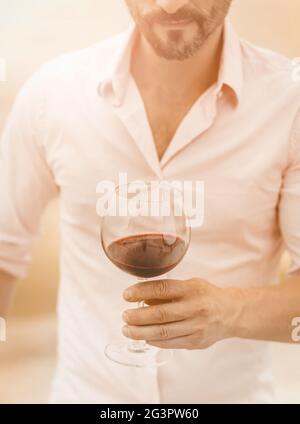 L'homme barbu tient un verre de vin rouge Banque D'Images