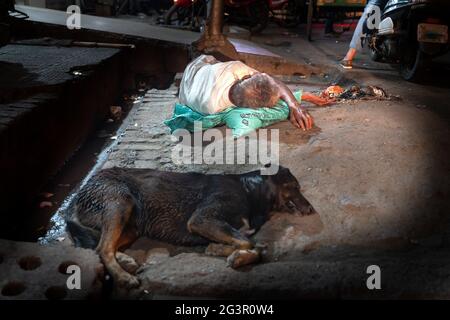 L'homme sans abri dormant dans la rue avec son chien Banque D'Images