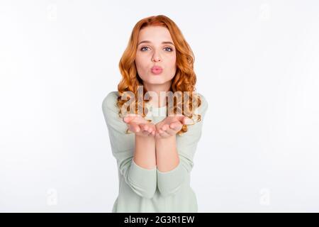 Photo portrait d'une fille à cheveux rouges envoyant un baiser d'air avec des lèvres pouted isolé couleur blanc arrière-plan Banque D'Images