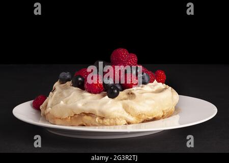 Dessert à la meringue Pavlova avec des mûres fraîches et des framboises. Banque D'Images