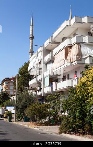 Alanya, Turquie - vers octobre 2020: Les immeubles et maisons d'appartements sont situés en face de la mosquée Kazim Bulut. C'est la plus grande mosquée traditionnelle de Banque D'Images