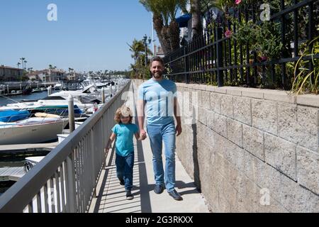 Marcher ensemble. Promenade du père et du fils tenant les mains. Homme et garçon enfant aiment la promenade tranquille Banque D'Images