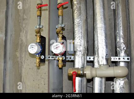 Compteur d'eau d'eau froide et chaude sur le fond de mur de brique dans le nouvel appartement. Dispositifs pour mesurer la quantité d'eau consommée Banque D'Images