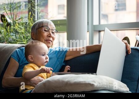 Grand-parent et petite-fille regardant l'ordinateur ensemble Banque D'Images