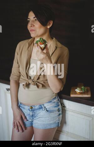 Femme mangeant des toasts sains et regardant dans la distance Banque D'Images