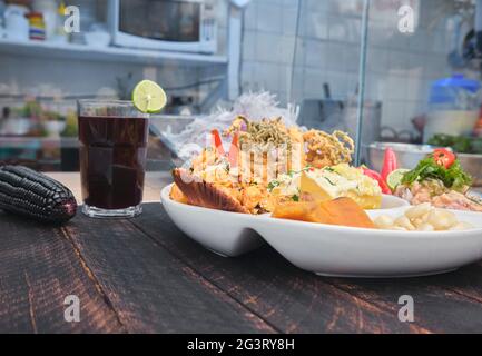 Cuisine péruvienne, fontaine de nourriture 'Ronda marina' UN assortiment de fruits de mer, ceviche classique + riz avec fruits de mer + poisson frit + thon de la pomme de terre de causa, foyer sélectif Banque D'Images