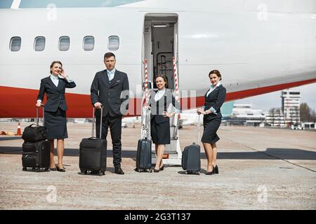 Équipe d'avions debout sur la piste près de l'avion Banque D'Images