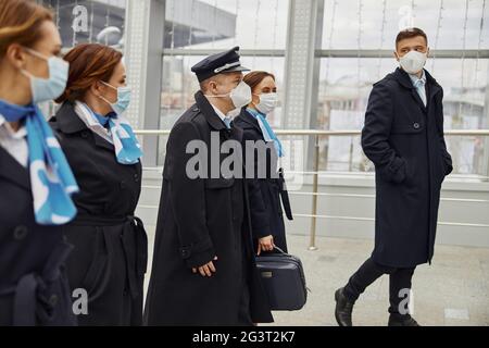 Une équipe d'avions se promenant ensemble dans un aéroport moderne Banque D'Images