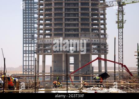 Nouvelle capitale administrative, Égypte. 17 juin 2021. Les gens travaillent sur le site de construction du projet du quartier central des affaires (CBD) dans la nouvelle capitale administrative, Égypte, le 17 juin 2021. Avec une vue imprenable sur les bâtiments modernes qui se trouvent dans le quartier des affaires (CBD) de la nouvelle capitale administrative de l'Égypte, les invités de Chine et d'Égypte ont organisé jeudi une cérémonie d'appoint pour la tour emblématique de 385 mètres de haut, qui sera le plus haut bâtiment d'Afrique une fois terminée. Credit: Sui Xiankai/Xinhua/Alay Live News Banque D'Images