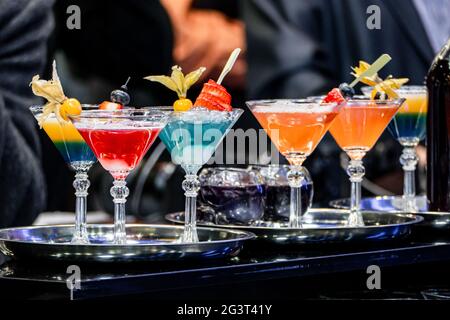De nombreux verres alcoolisés à la réception festive. Cocktail alcoolisé dans des verres décorés d'une tranche de citron sur le fond. Banque D'Images