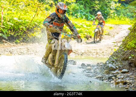 Deux athlètes Enduro traversant une petite rivière Banque D'Images