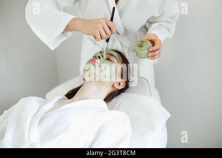 Belle femme détendue ayant le masque de visage d'argile Banque D'Images