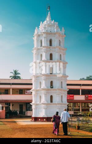 Kavlem, Phonda, Goa, Inde. Personnes marchant près de Shree Shantadurga Mandir, Temple de Kavlem. Site d'intérêt célèbre et destination populaire. Tour de lampe blanche Banque D'Images