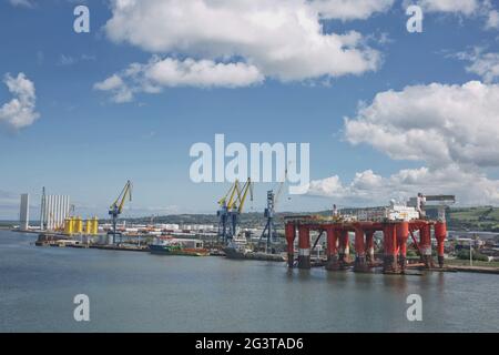 Grandes grues industrielles chargeant des conteneurs à bord du port de Belfast en Irlande Banque D'Images