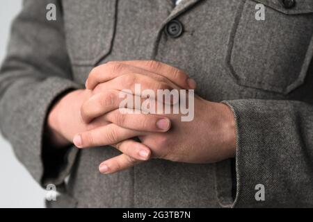 Un jeune homme d'affaires qui met les mains sur sa poitrine écoute attentivement son adversaire. Un jeune homme dans une veste d'affaires s Banque D'Images