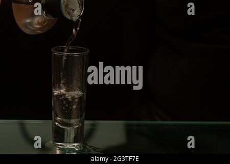 Boisson alcoolisée Tequila servie de manière forte l'esprit de la boisson s'écoule entre les bulles qui explosent entre le liquide distillé Banque D'Images