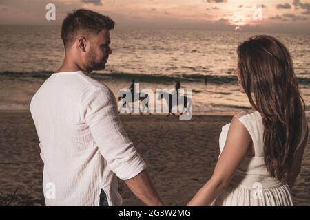 Couple romantique sur la plage au coucher du soleil Banque D'Images