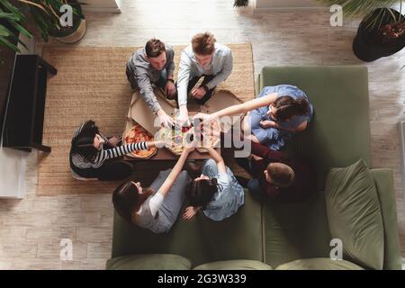 Pizza party, groupe d'amis discutant, manger de la pizza, boire de l'eau douce de soda Banque D'Images