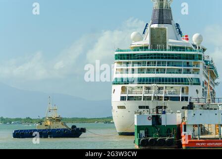 Le navire de croisière Rhapsody of the Seas arrive à ports North à Cairns, Queensland, en Australie, guidé par un remorqueur. Banque D'Images