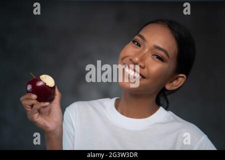 Portrait d'une belle jeune femme souriante avec pomme rouge Banque D'Images