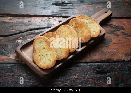 Tranches de baguette grillées sur une table de cuisine rustique en bois Banque D'Images