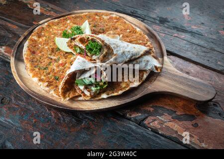 Lahmacun pizza traditionnelle turque et wraps avec salade sur table rustique en bois Banque D'Images