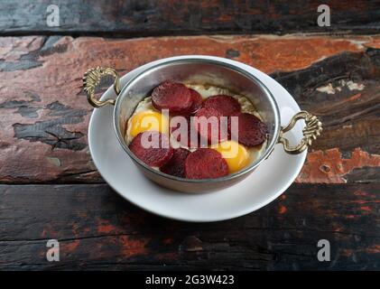 Saucisse turque (sucuk) et œuf sur une table rustique en bois Banque D'Images