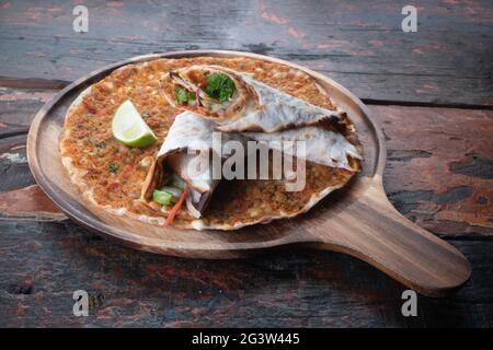 Lahmacun pizza traditionnelle turque et wraps avec salade sur table rustique en bois Banque D'Images