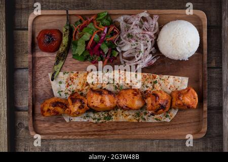 Poulet turc sis kebab avec du riz et des légumes sur une table rustique en bois Banque D'Images